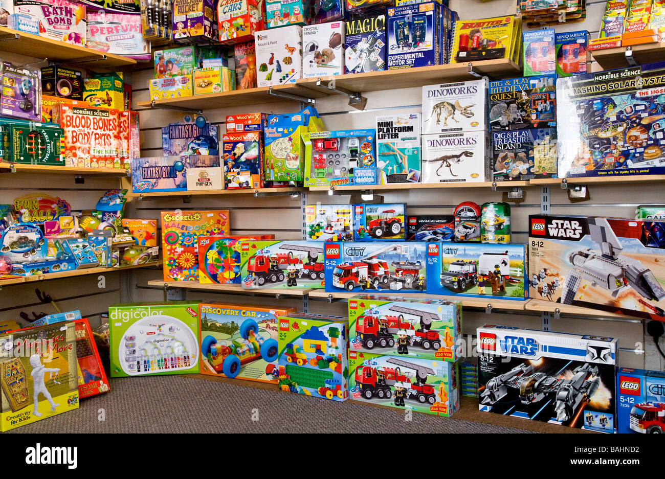 Boxes of creative toys and games for children on shelves inside a toy shop or store Stock Photo