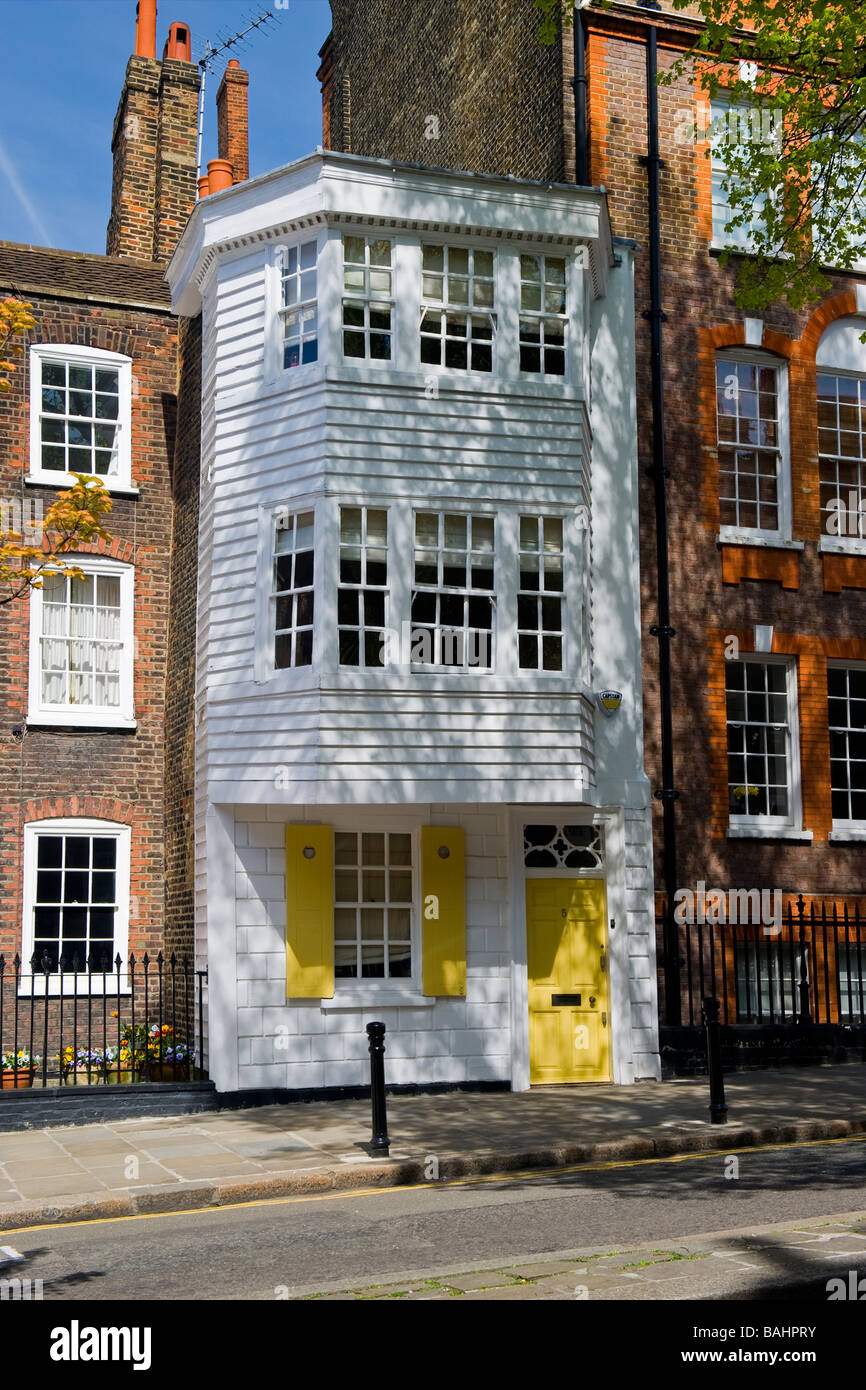Spring in Hampstead Village , the unique picturesque wood clad old Georgian house of No 5 Church Row , yellow wooden front door Stock Photo