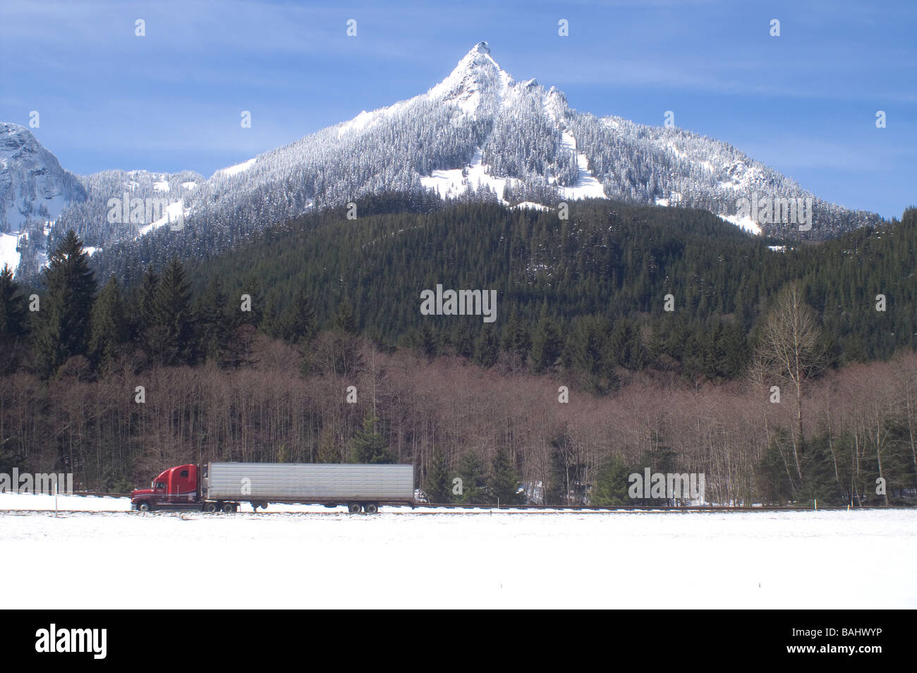 A Semi Truck on Snow Covered Snoqualmie Pass I-90 Cascade Mountains Washington State Stock Photo