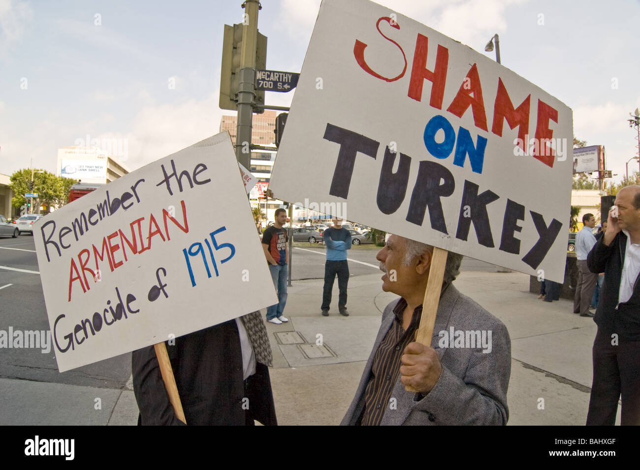 Two Armenian men hold up posters in rememberence of the Armenian