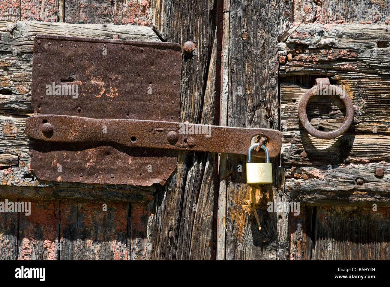 A rusting hasp & staple on a crumbling door in Linari, Tuscany, Italy Stock Photo