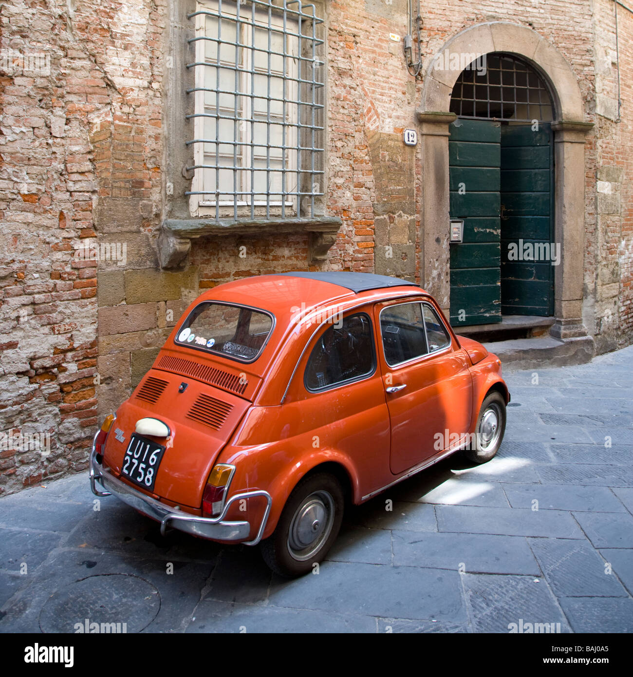 An orange Fiat 500 in an alleyway of Lucca, Tuscany, Italy Stock Photo ...