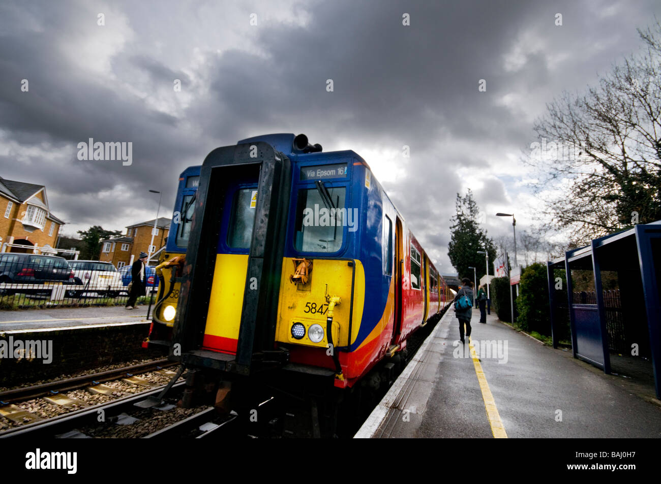 Bad Weather & Train on platform, Surrey, UK Stock Photo