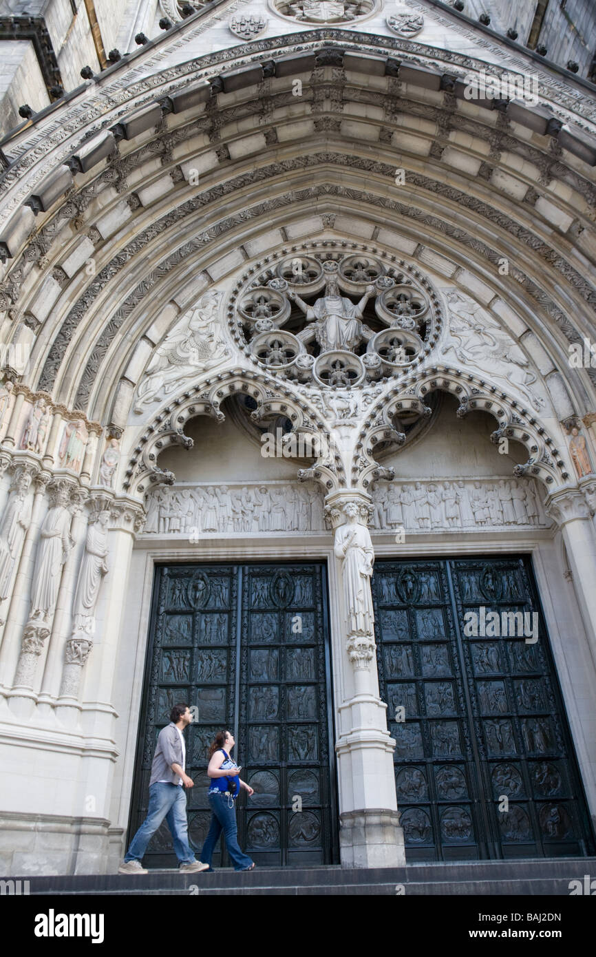 Main entrance door dwarfs tourists Cathedral of Saint John the Divine New York City Stock Photo