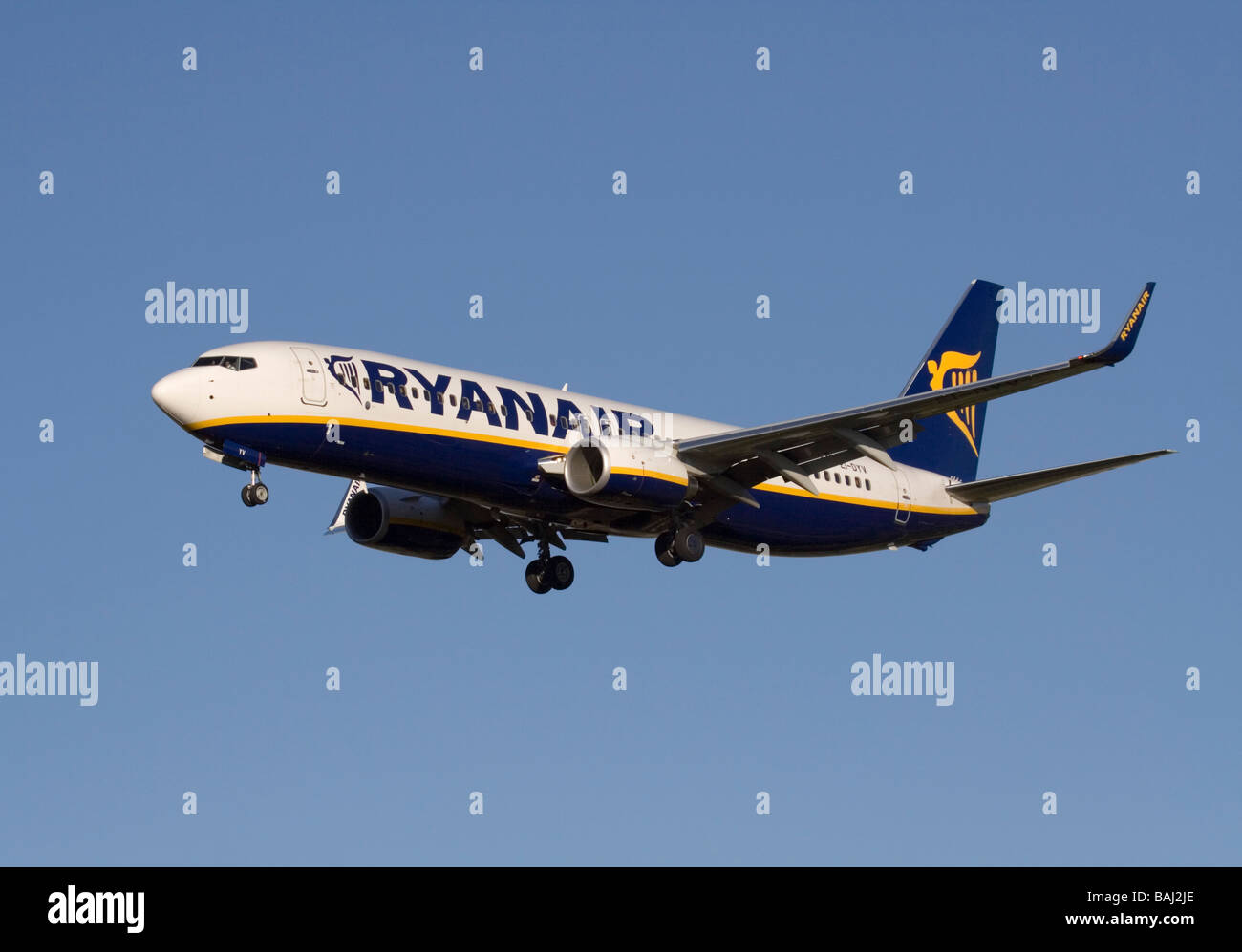 Cheap air travel and mass tourism. Ryanair Boeing 737-800 jet airplane on final approach against a clear blue sky Stock Photo