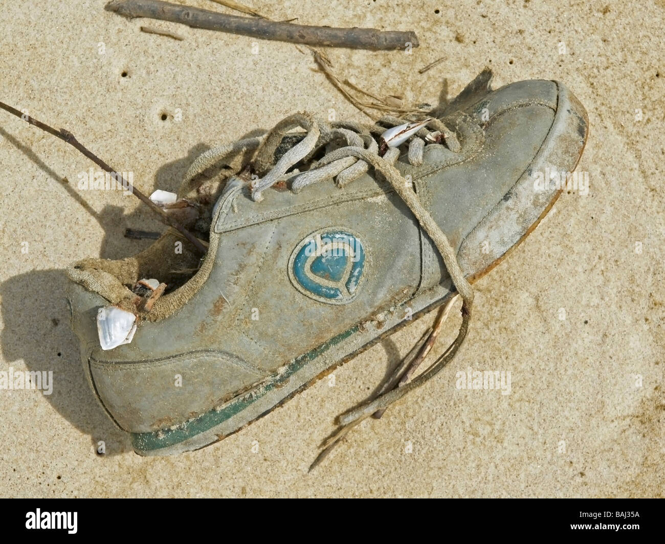 washed up kaputt shoe with sand at the coast of Atlantic Ocean France Stock Photo