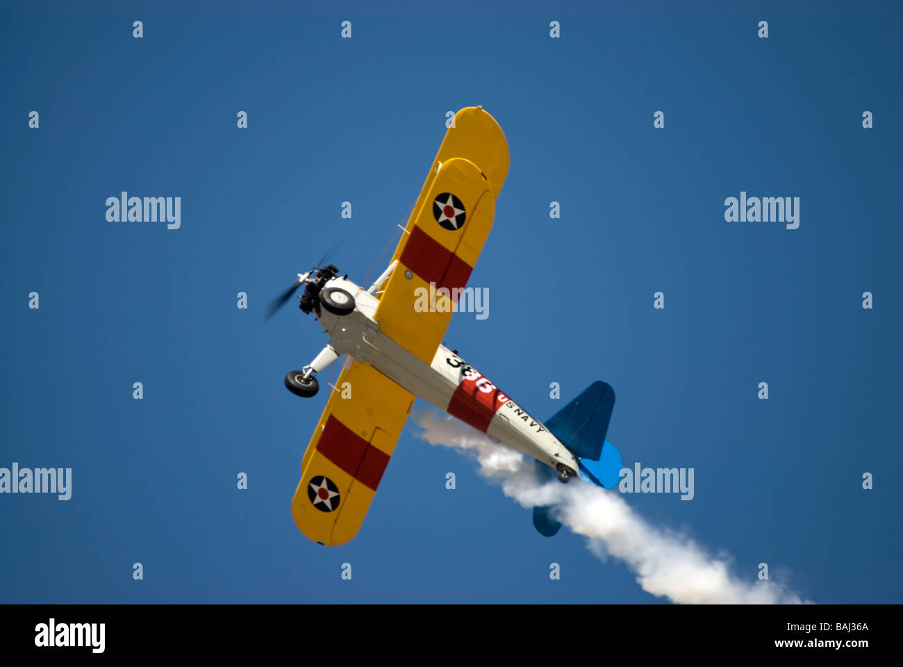 A US Navy version of the Stearman biplane trainer - in flight and seen from a sharp angle from below. Stock Photo