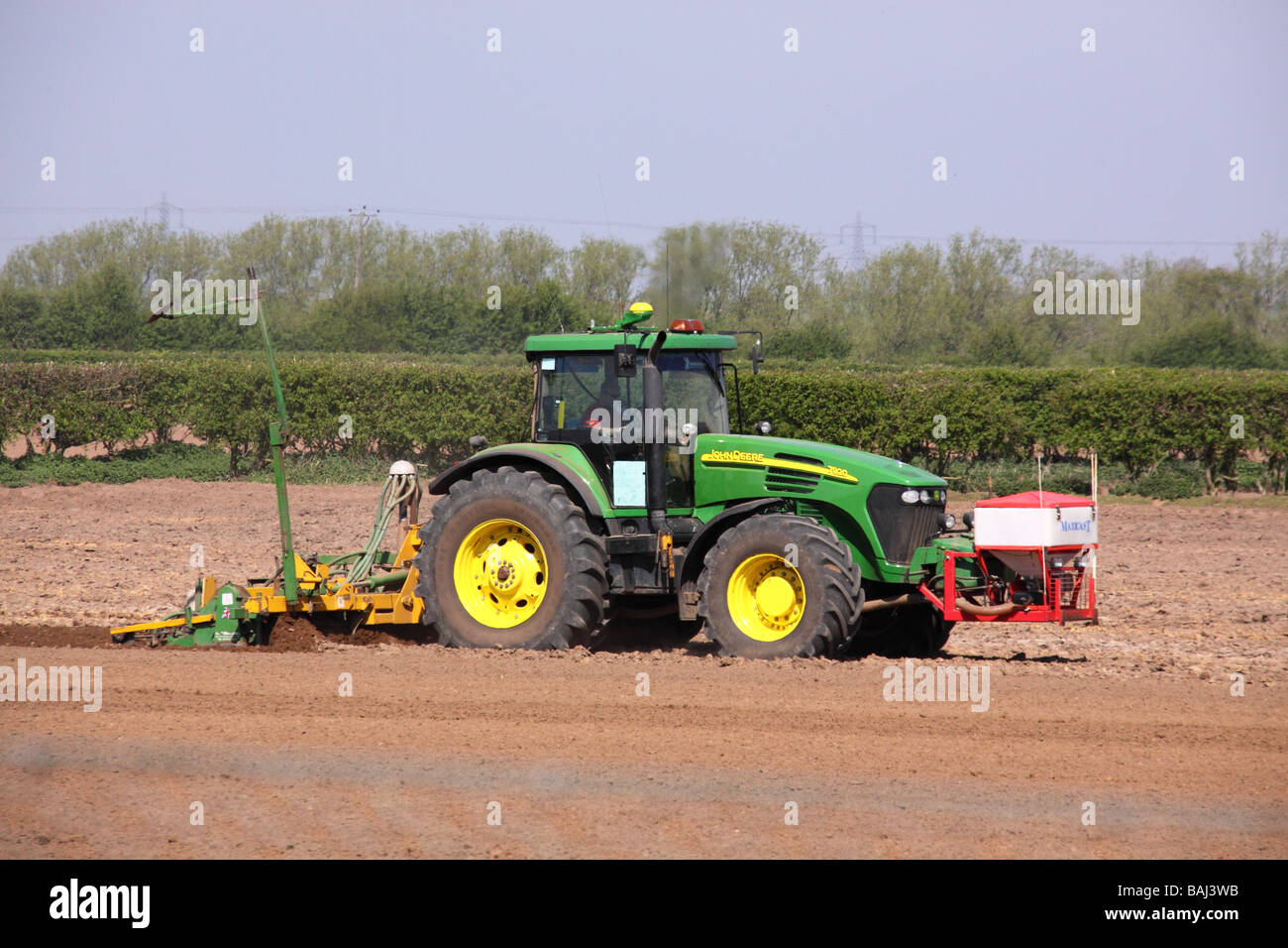 john deere green tractor working in a field sowing seed Stock Photo