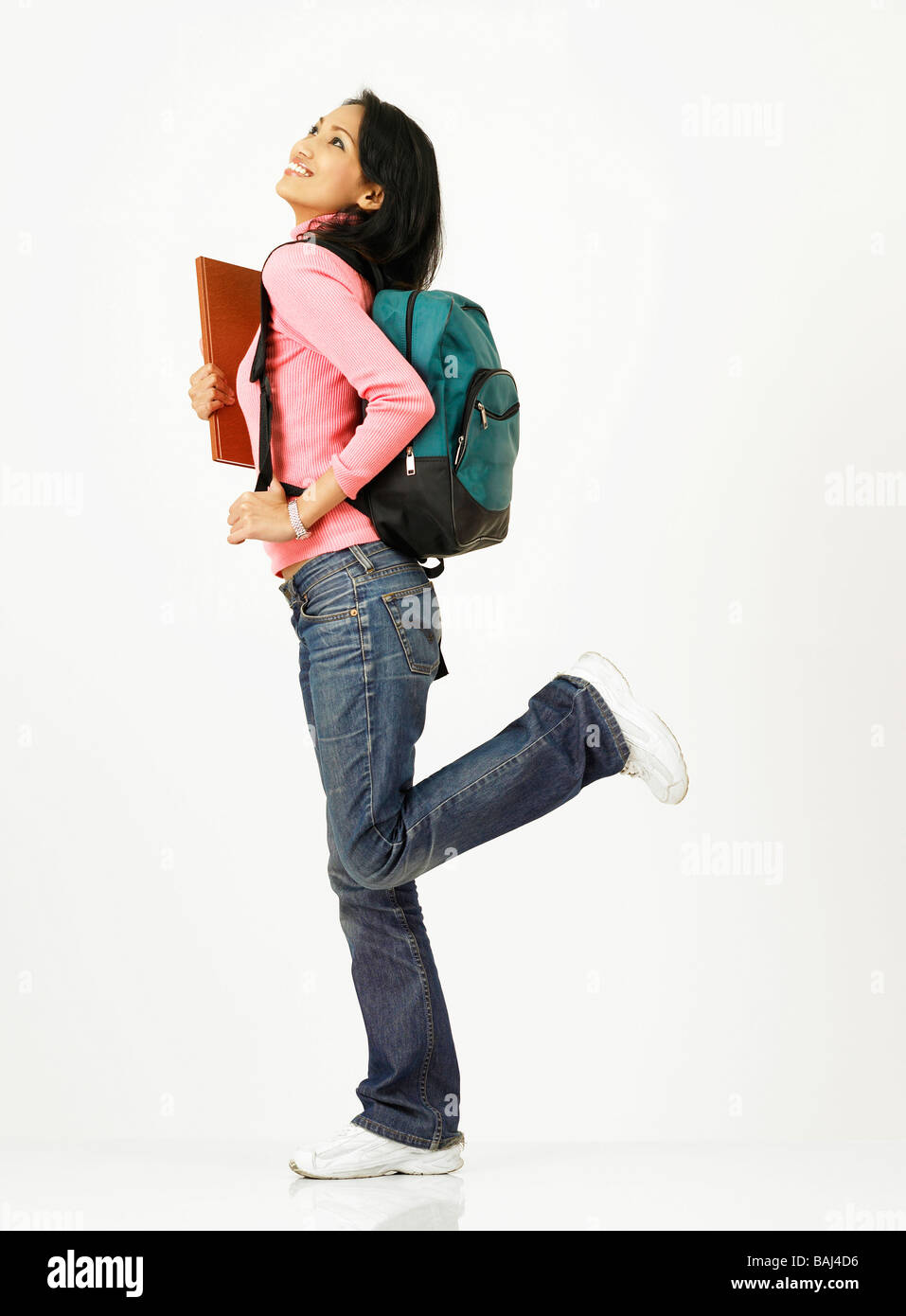 profile of girl with backpack holding book Stock Photo - Alamy
