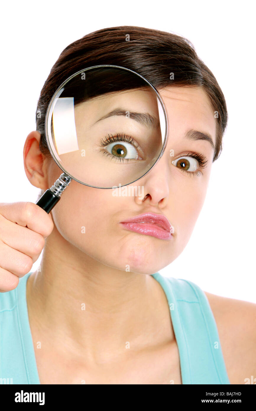 Junge Frau mit Vergroesserungsglas, eye of a woman oversized through a magnifier glass Stock Photo