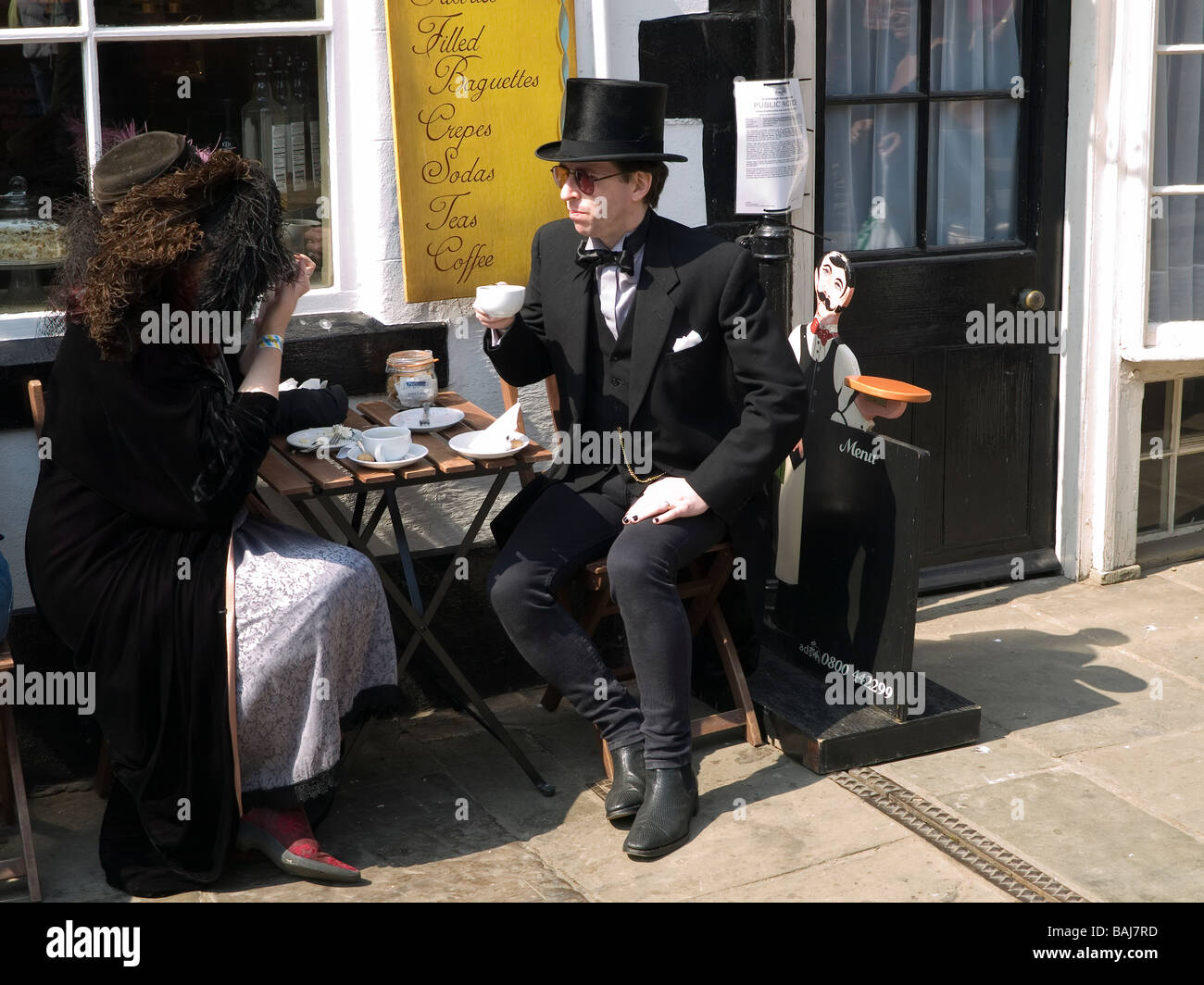 A man and woman dressed as Goths enjoy a cup of coffee at the biannual Goth festival in Whitby Stock Photo
