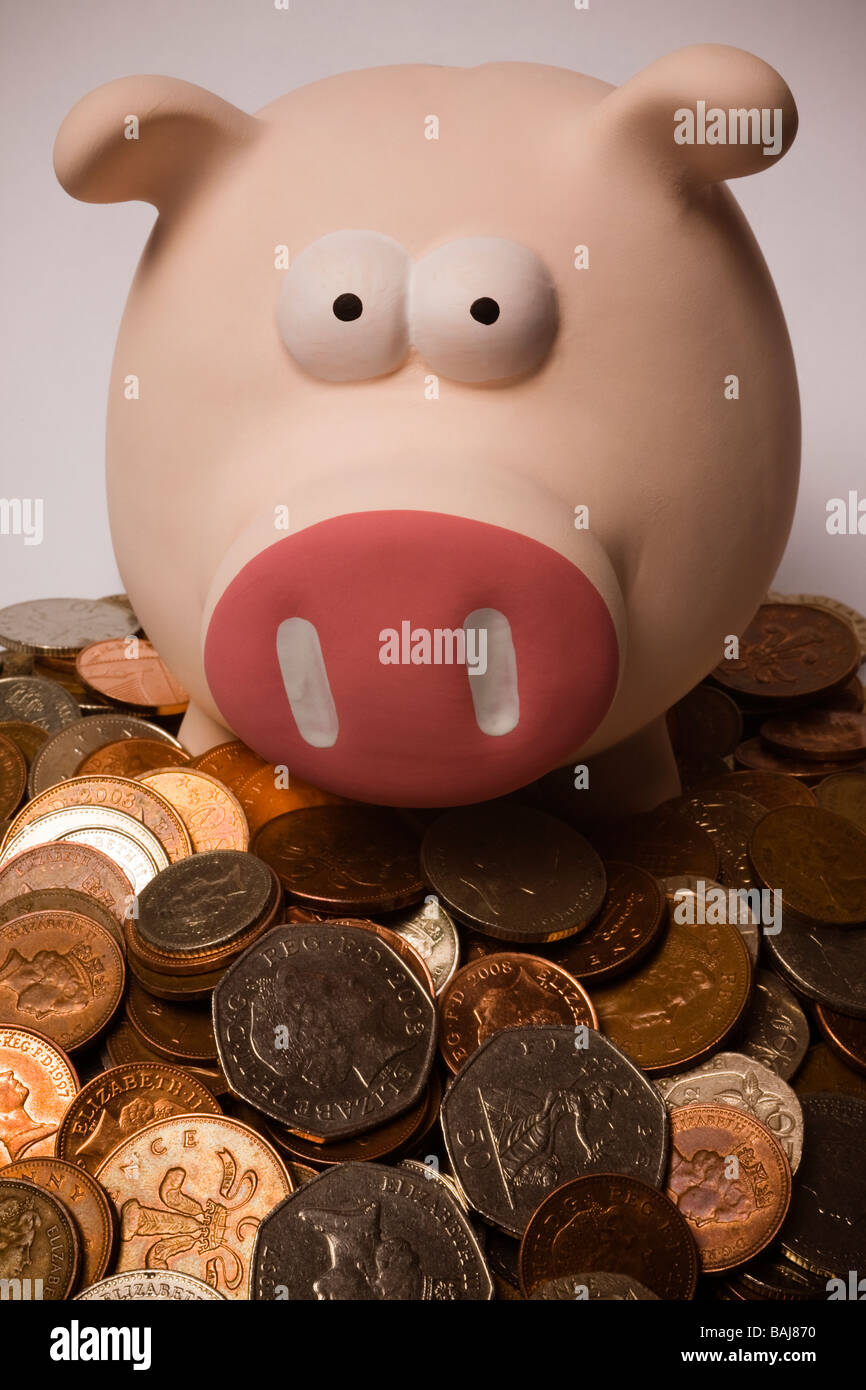 piggy bank sitting on top of a pile of British coins Stock Photo - Alamy