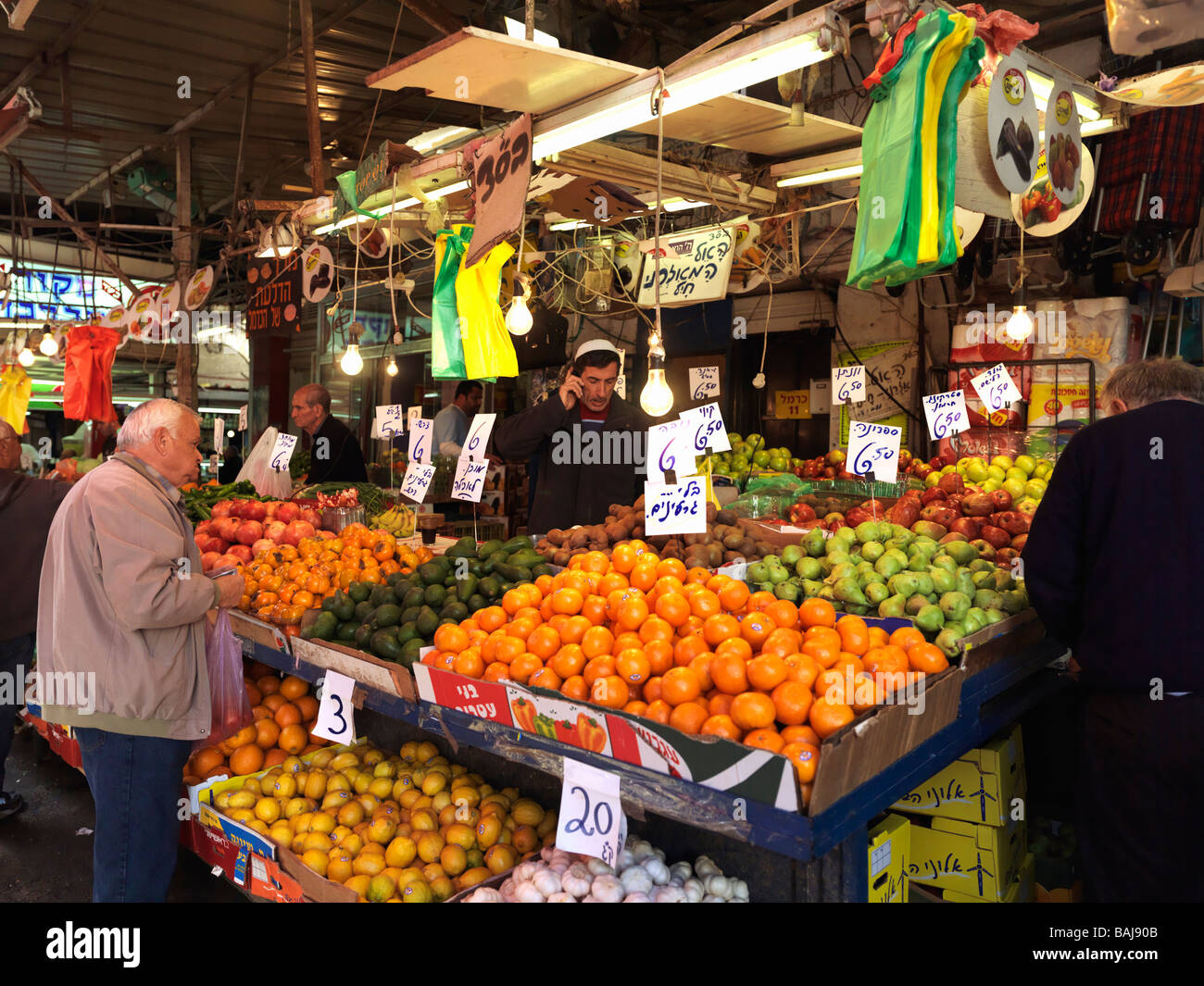 Israel Tel Aviv Carmel Market fresh fruit stand and shoppers Stock Photo