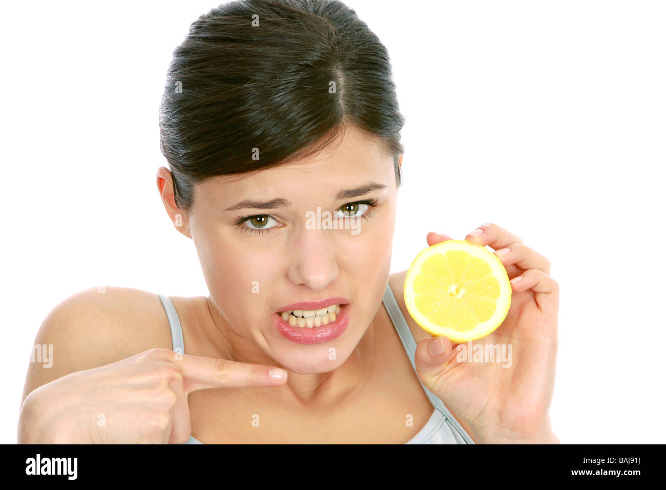 Junge Frau mit Zitrone macht Grimasse, Woman making face at lemon Stock Photo