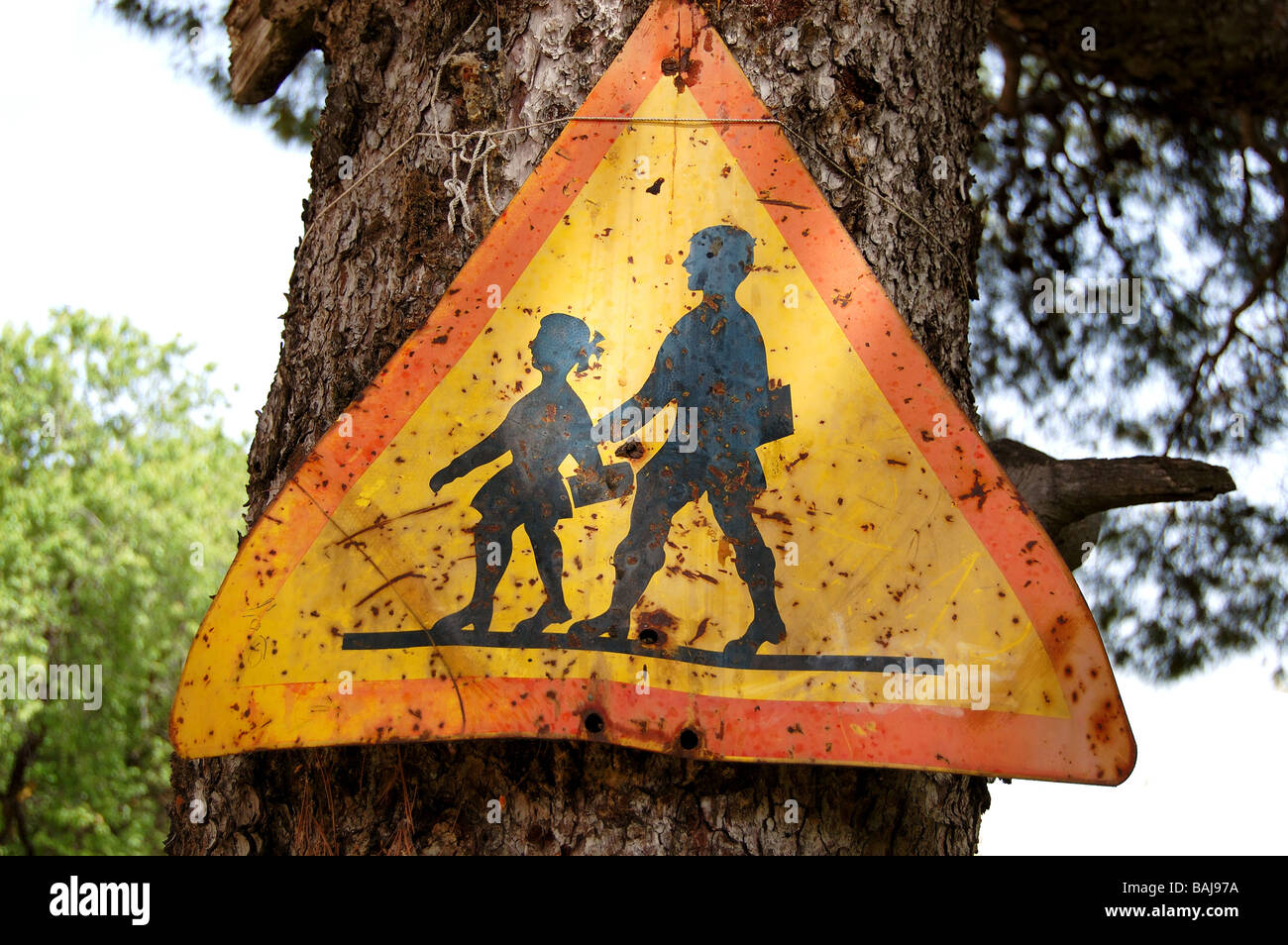 Old rusty traffic control warning sign for school children. Speed restriction. Stock Photo