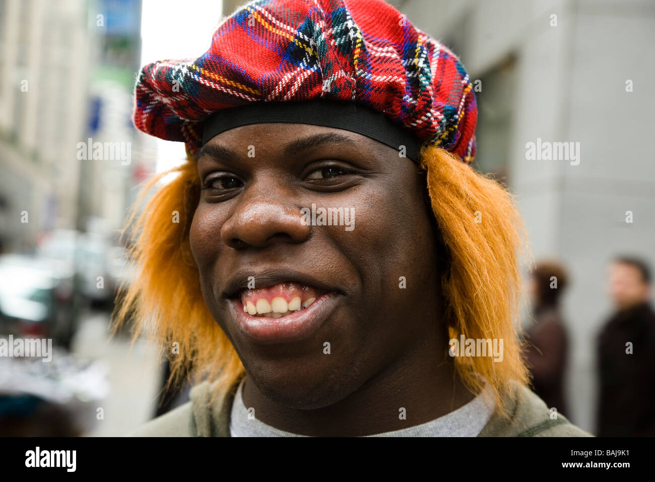 Man dressed with tartan hat and wig with red hair known as a see you Jimmy hat at the Tartan Day Parade in New York America Stock Photo