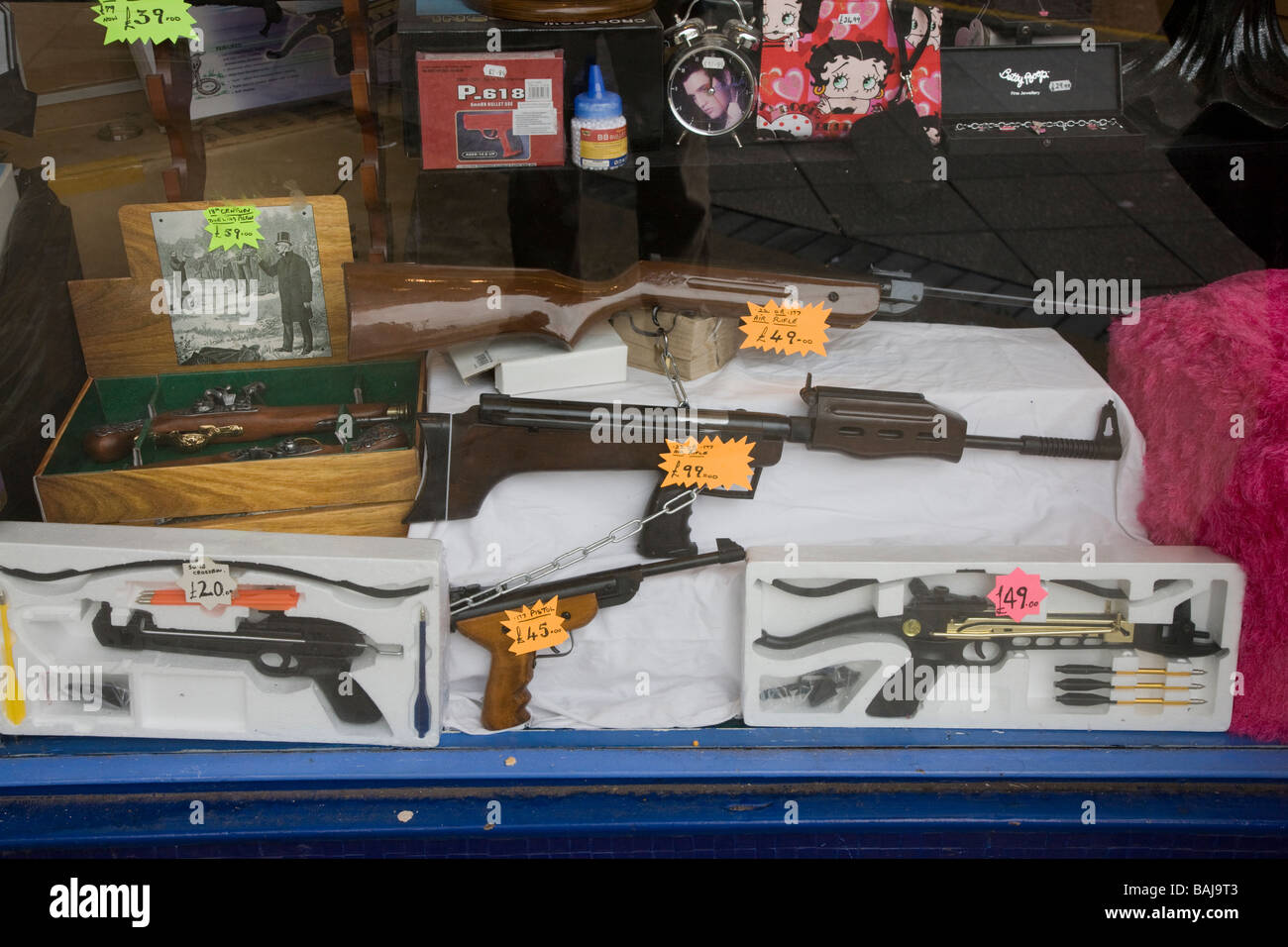 Air guns crossbows and other dangerous weapons for sale in a gun shop window Stock Photo