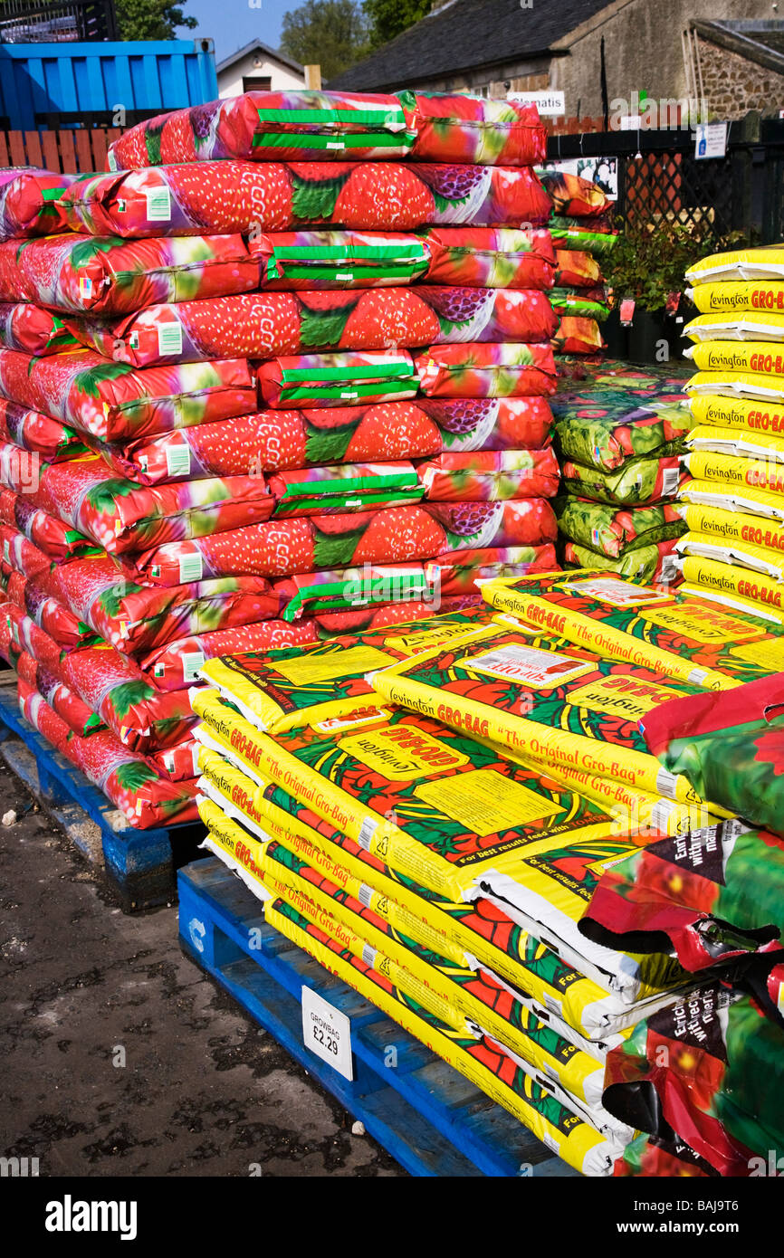 Bags of compost stacked on pallets at a garden centre. Stock Photo