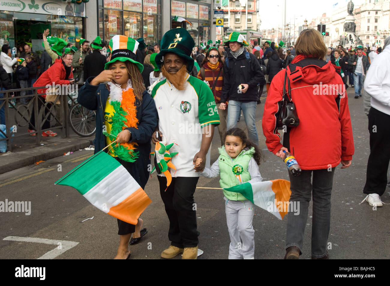 Family on the move with crowds at St Parick's Day parade, Dublin, Ireland Stock Photo