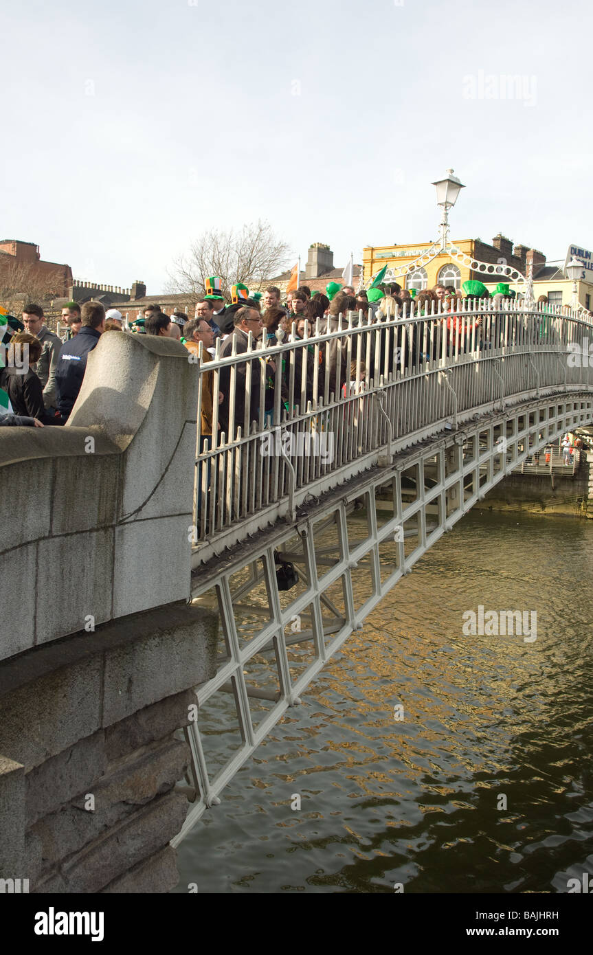 Crowds crossing Half Penny Bridge on St Patrick's day in Dublin, Ireland Stock Photo
