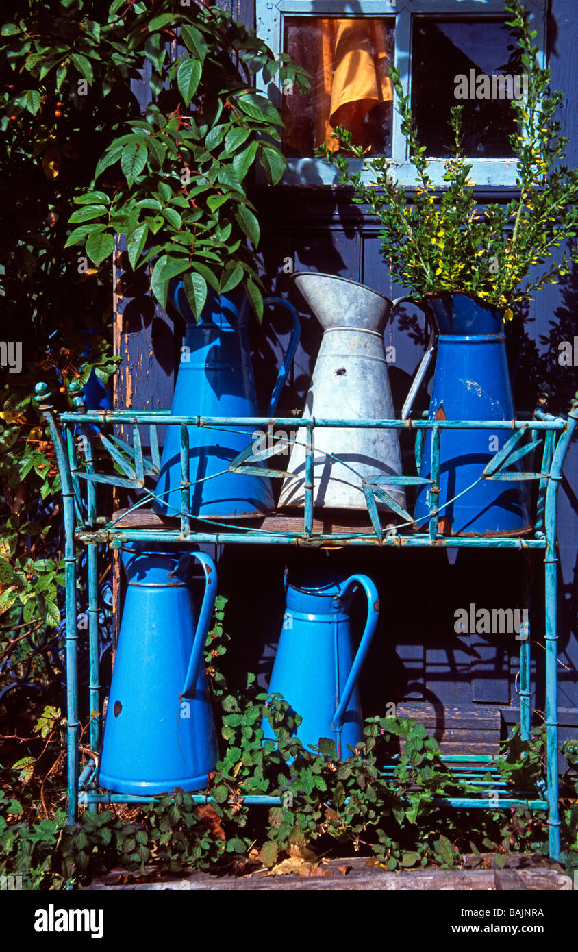 Blue enamel jugs outside rustic garden shed, Aveyron, rural France Stock Photo