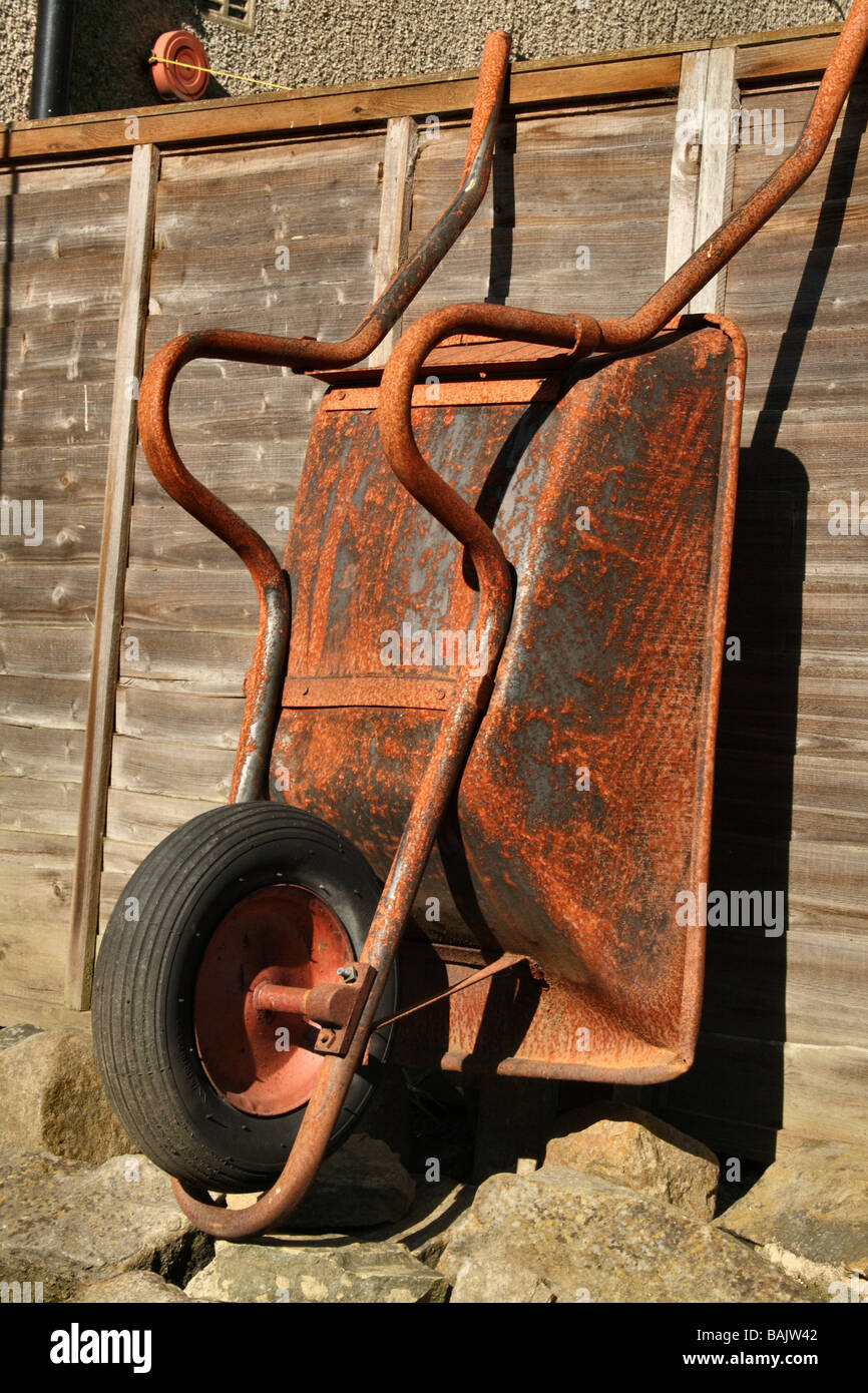 Rusty Wheel Barrow used in the Garden Stock Photo