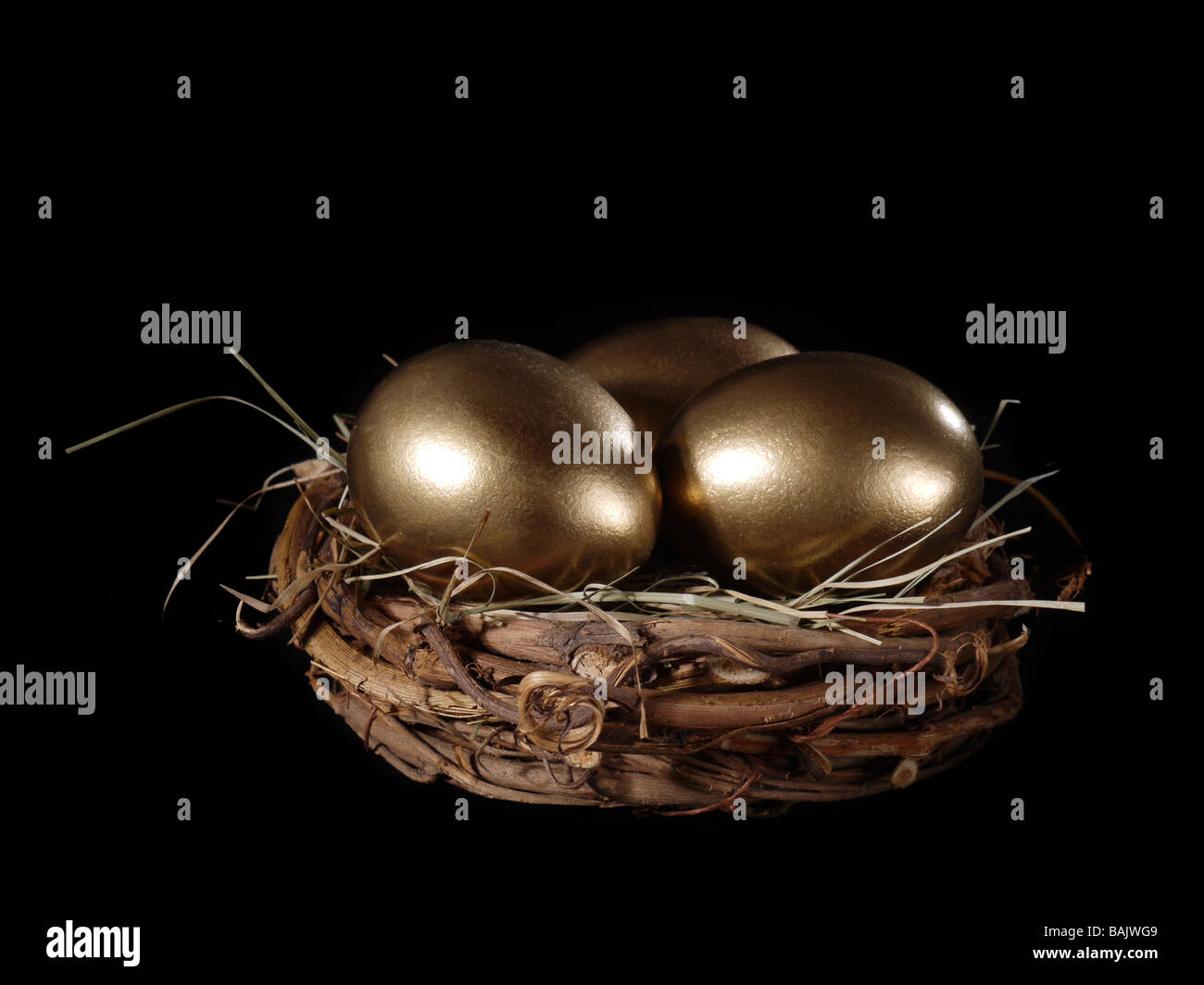 Three golden eggs in bird s nest over black background Stock Photo