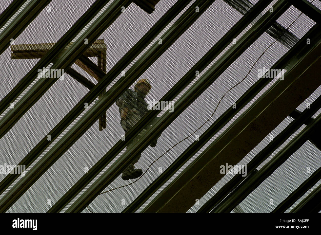 Construction worker laying the roof on a factory building Stock Photo
