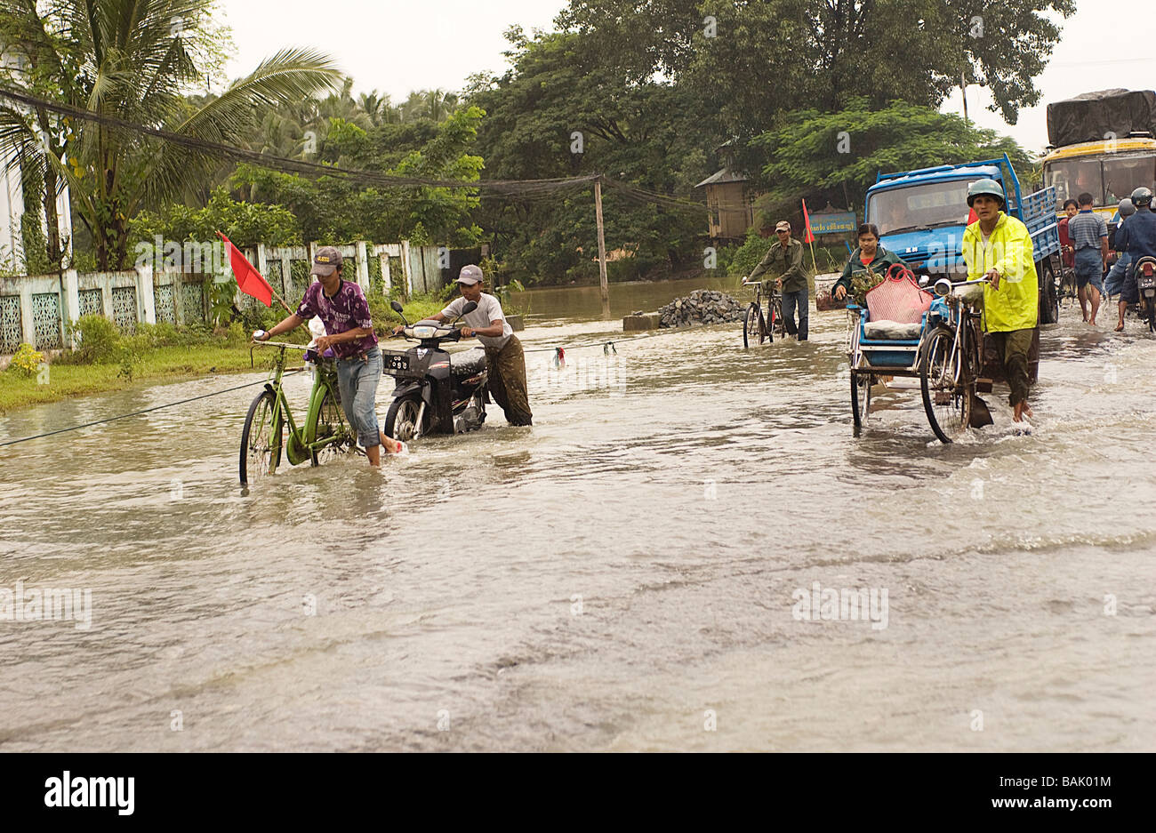 Myanmar (Burma), Bago Division, Pegu, monsoon rain and traffic on the road flooded by Pegu River Stock Photo
