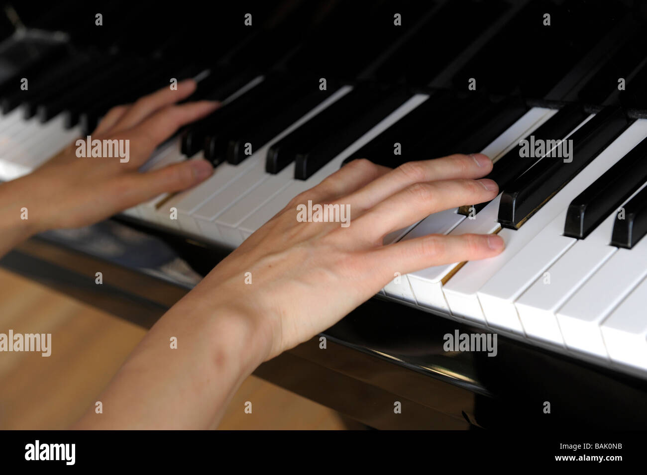 Close-up of hands playing a grand piano Stock Photo