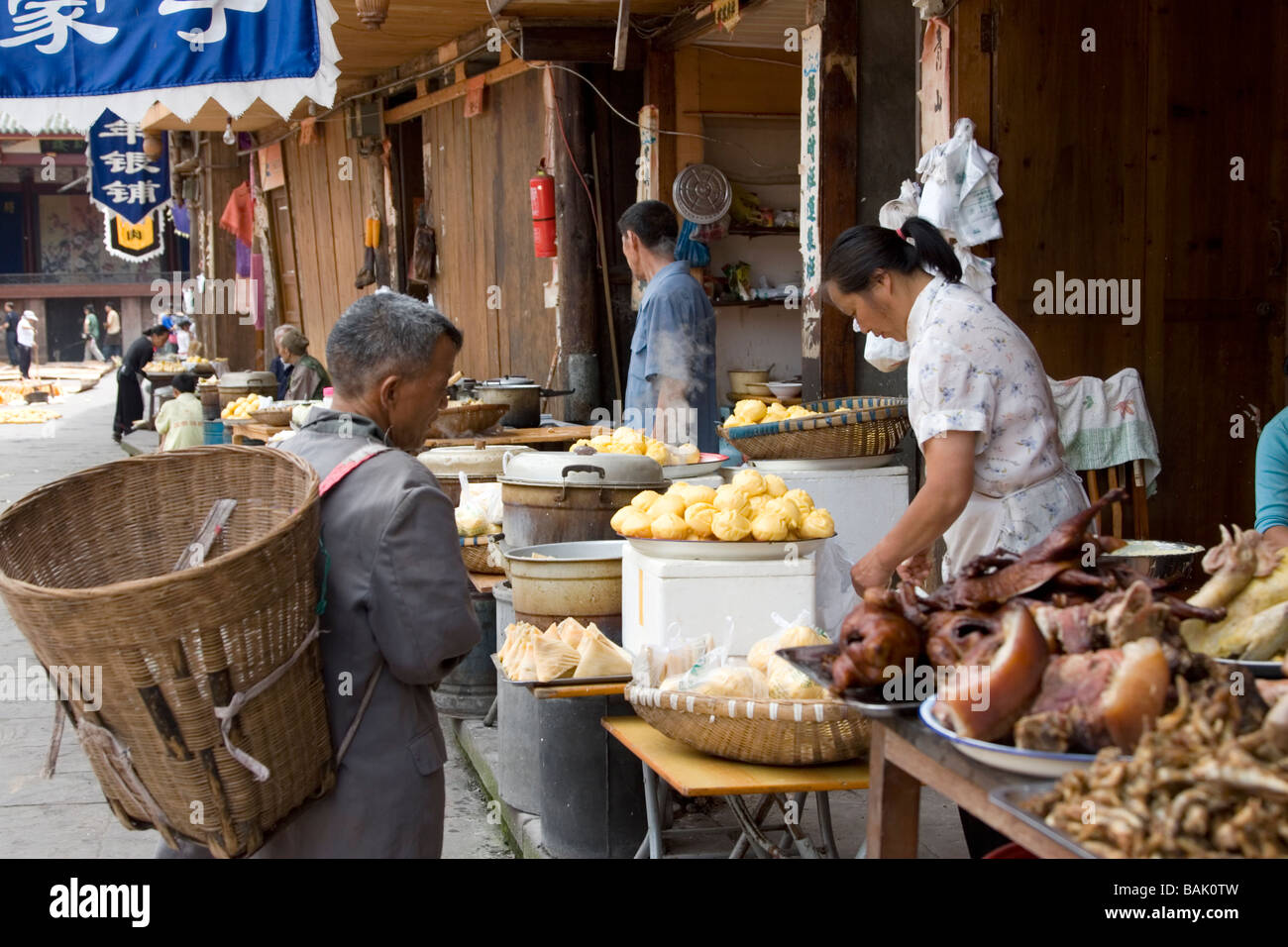 People shopping for rustic foods at an eatery in the main square of Shangli in Sichuan in China. Stock Photo