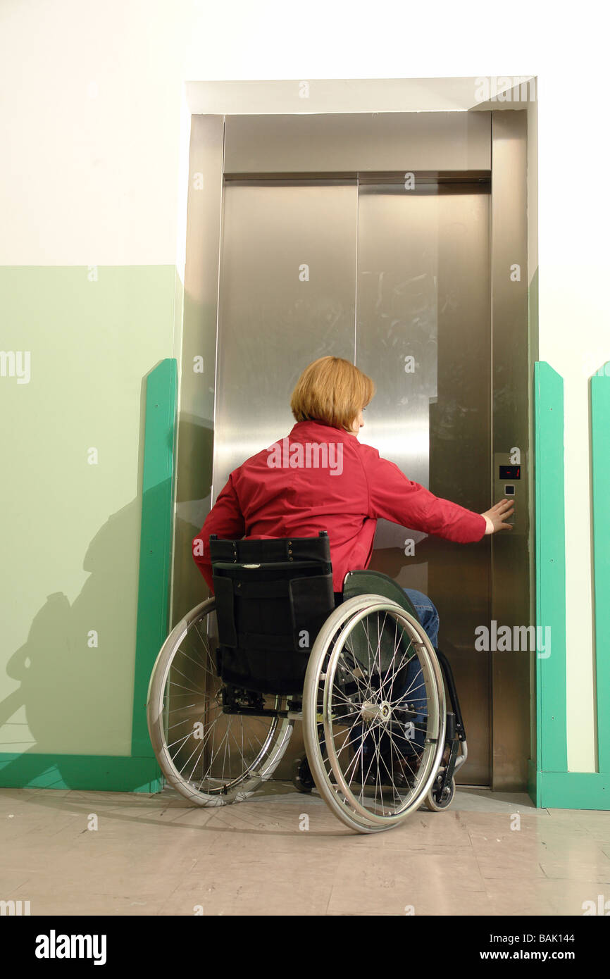 Handicapped woman on wheelchair using lift in building Stock Photo