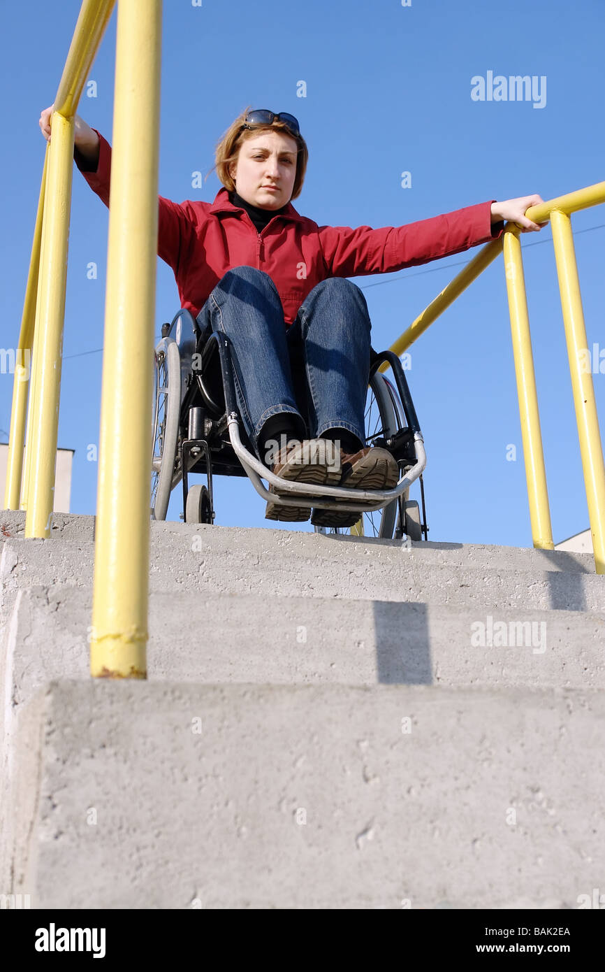 Handicapped woman on wheelchair going down the concrete stairs Stock