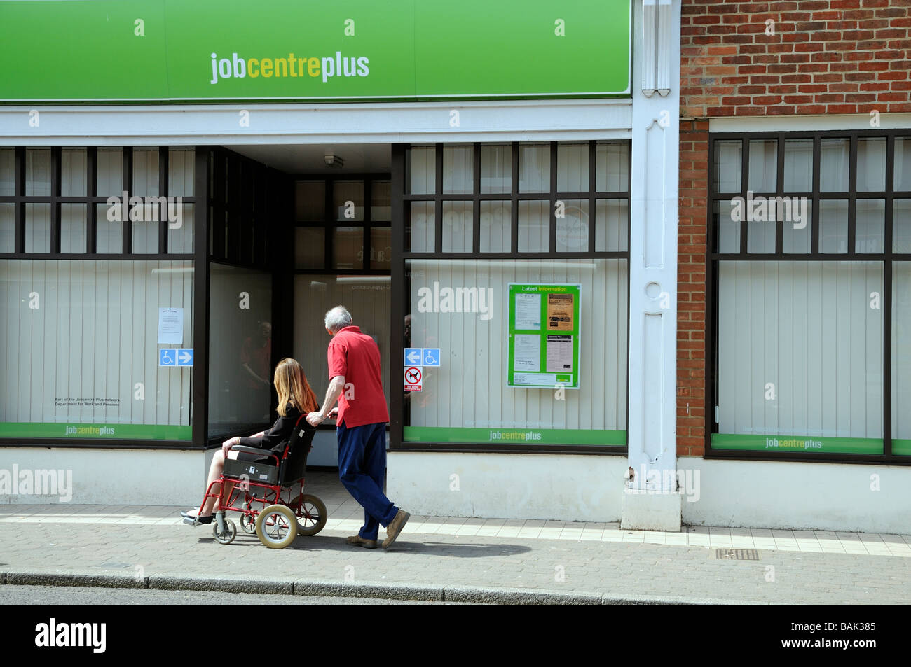 Female wheelchair user and male carer visiting a job centre plus office