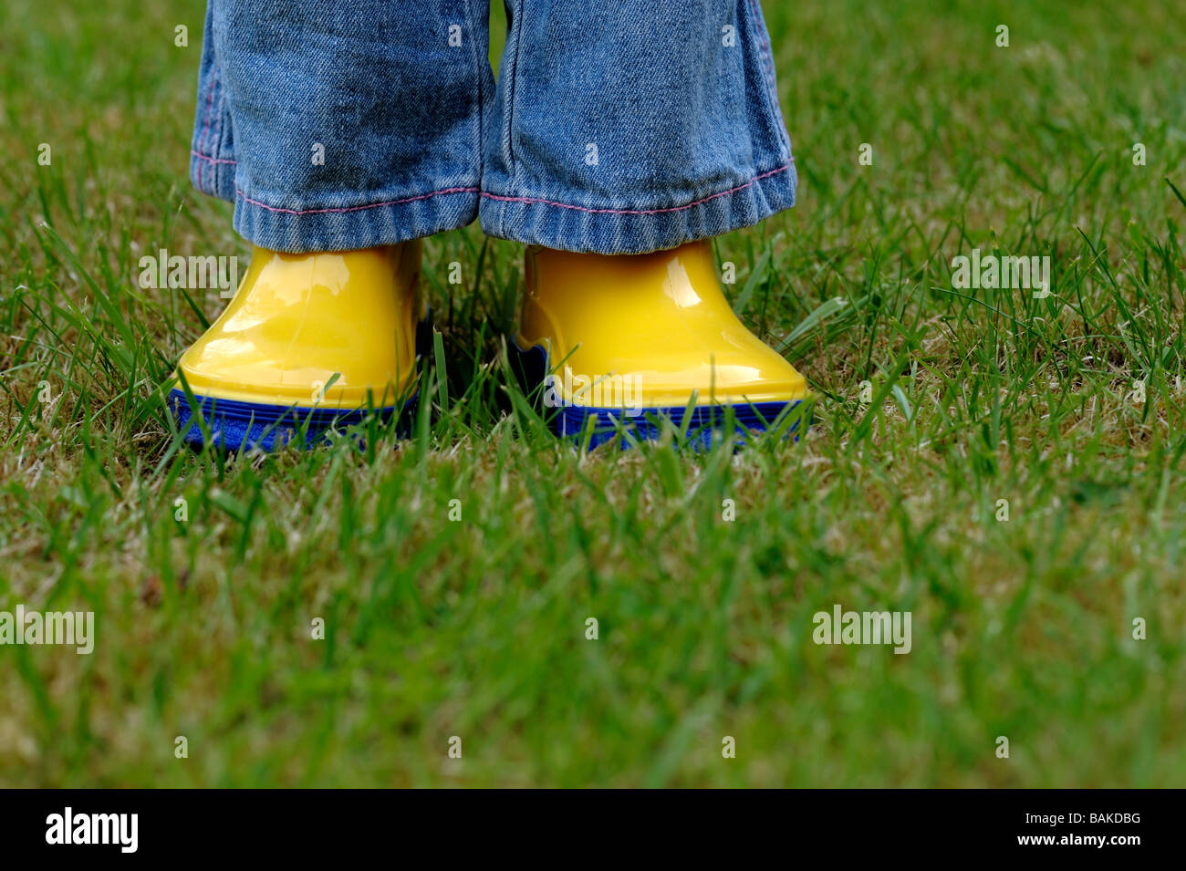 Girl on lawn wearing wellington boots Stock Photo - Alamy