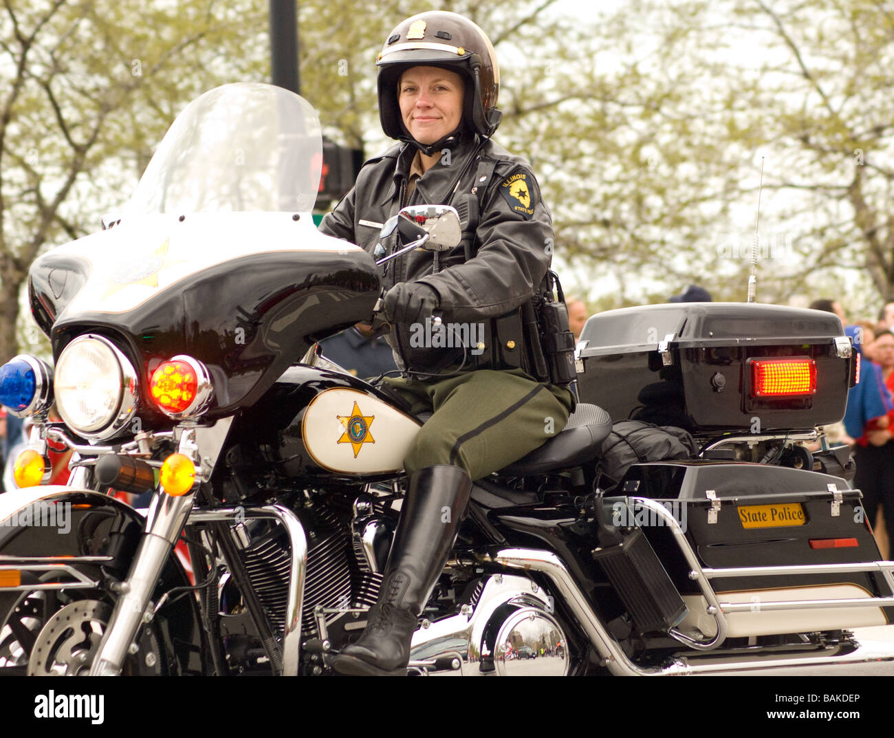 Grinning female state trooper drives motorcycle in Chicago Polish Parade Stock Photo