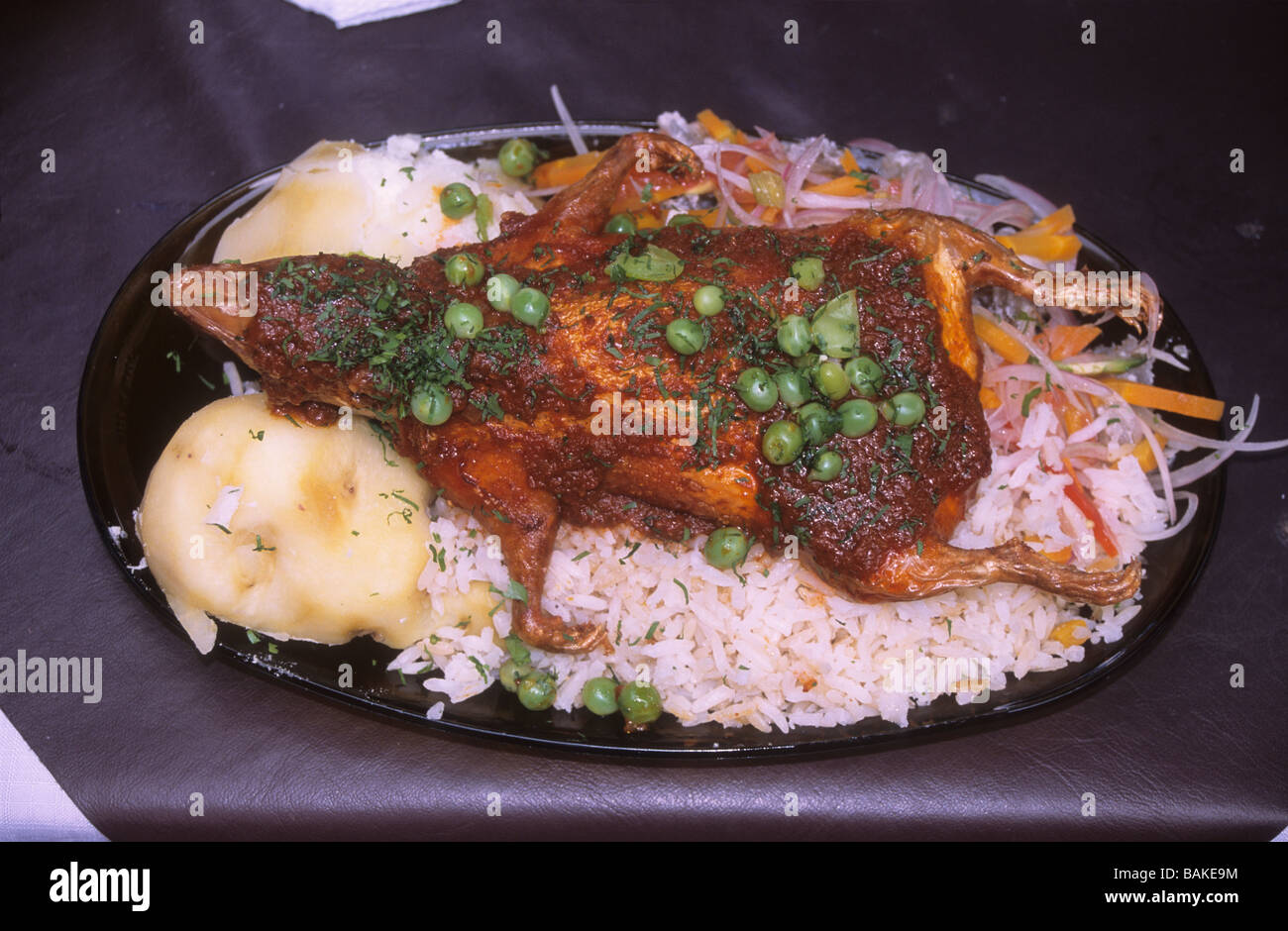 Cuy or guinea pig, a popular dish in Peru and also Ecuador and Quechua speaking parts of Bolivia. Here served with rice, potatoes and salad. Stock Photo