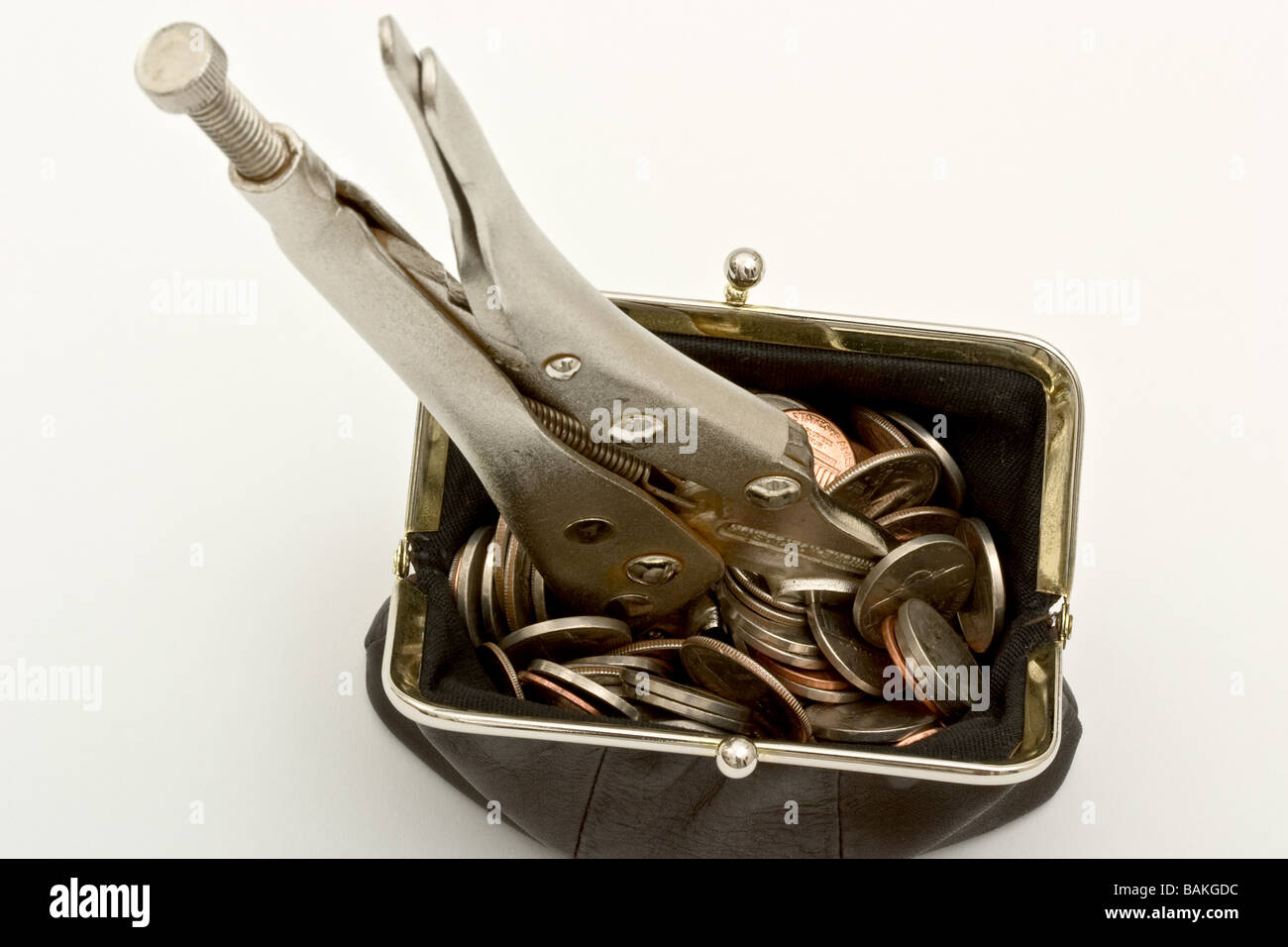 Adjustable wrench in a leather purse filled with coins Stock Photo