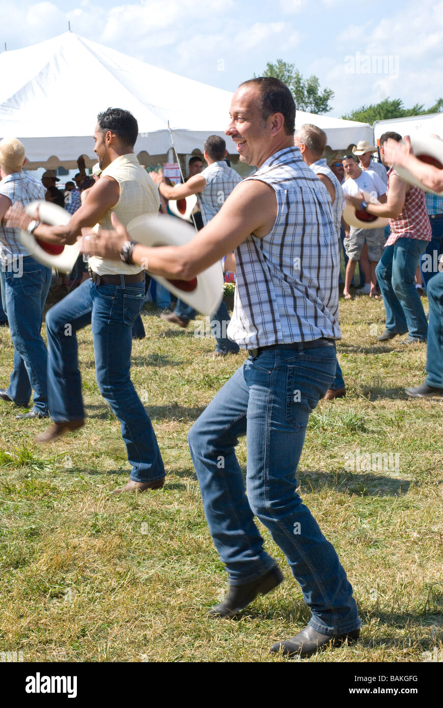 Gay men performing line dance at rodeo Stock Photo