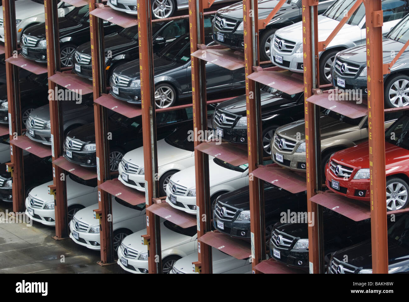 Economic recession hurts luxury car sales in the US. Cars are parked in vertical stacks four deep at a Mercedes-Benz dealership. Stock Photo
