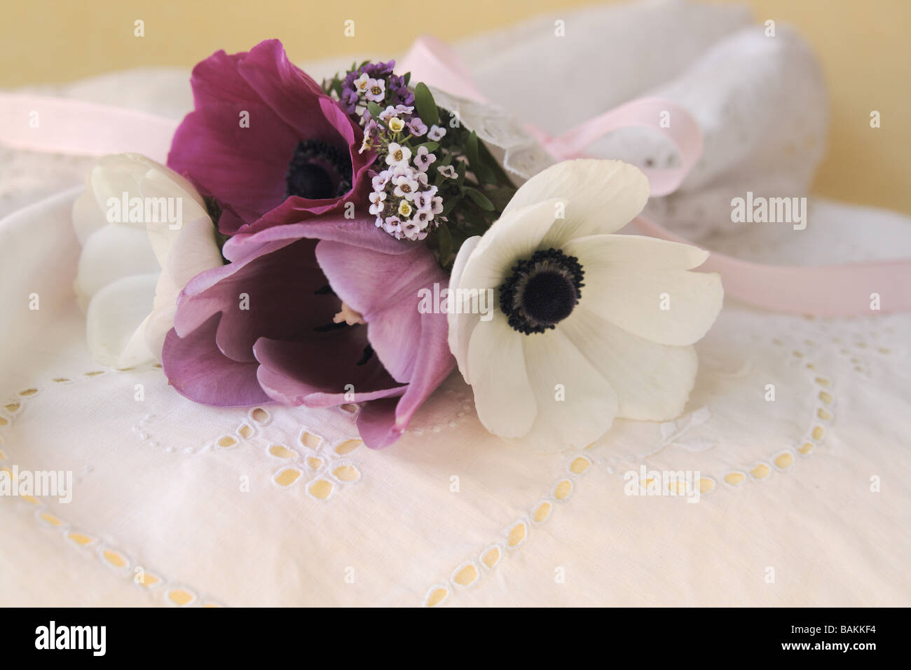 purple and white anemones with eyelet fabric and pink ribbon Stock Photo