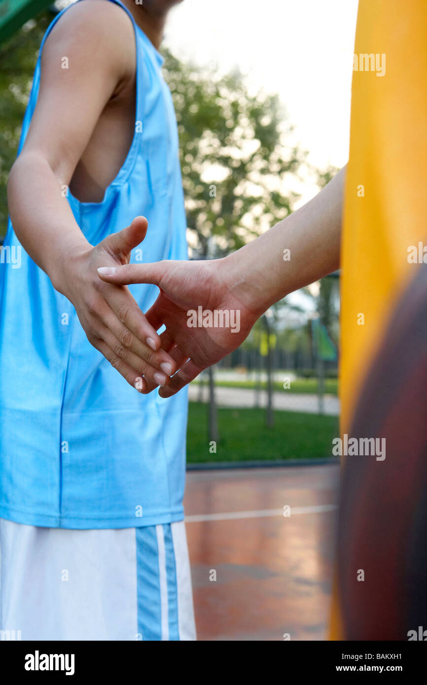 Young Men Shaking Hands On A Basketball Court Stock Photo