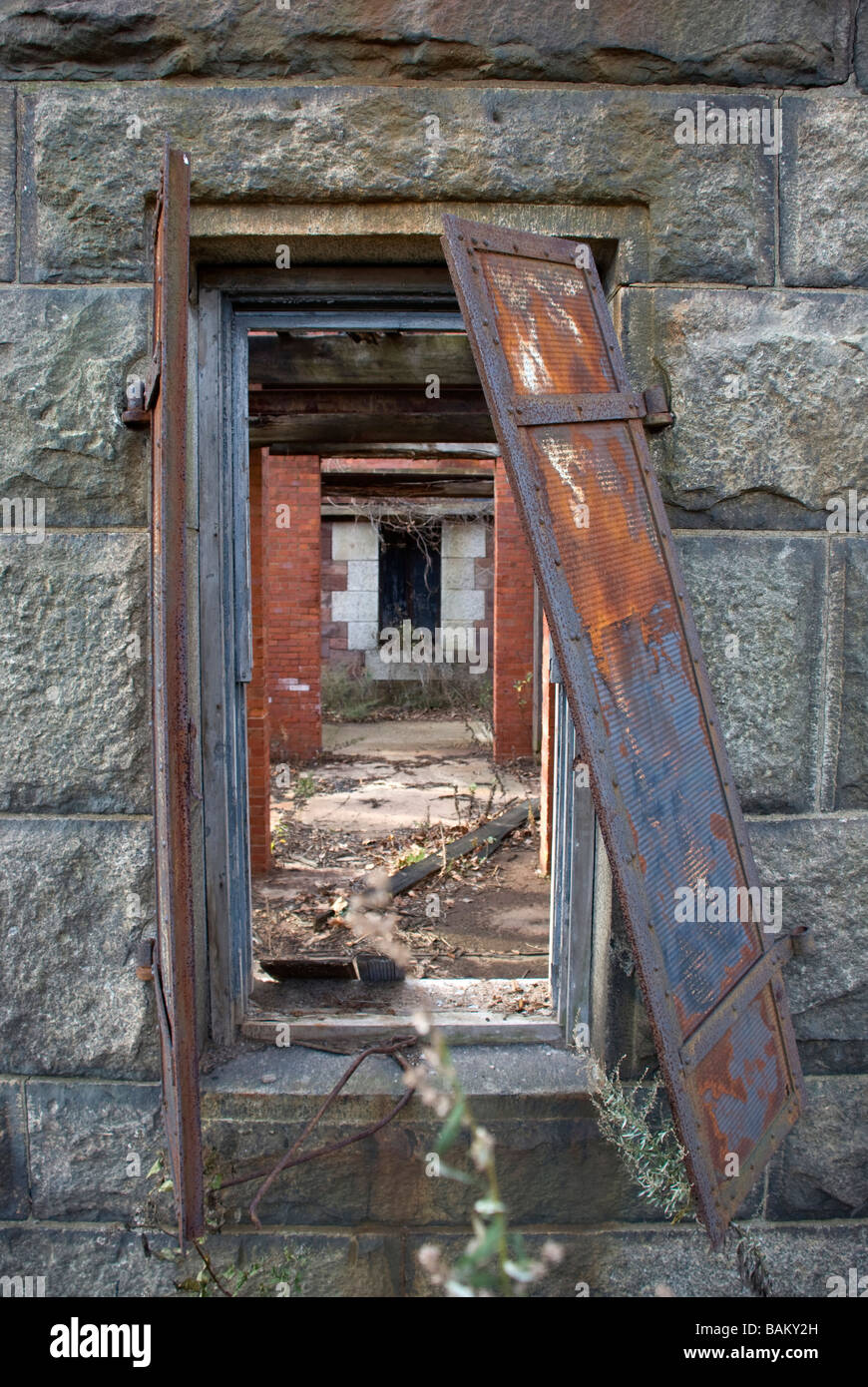an empty old deserted stone building with open doors and rusty iron ...