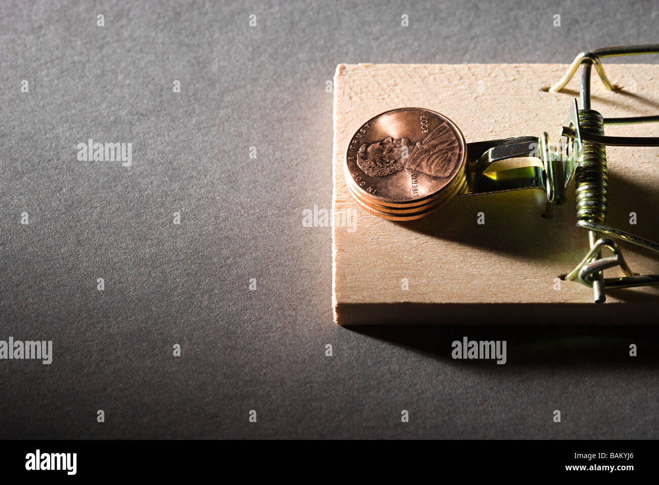 Coins on mousetrap Stock Photo