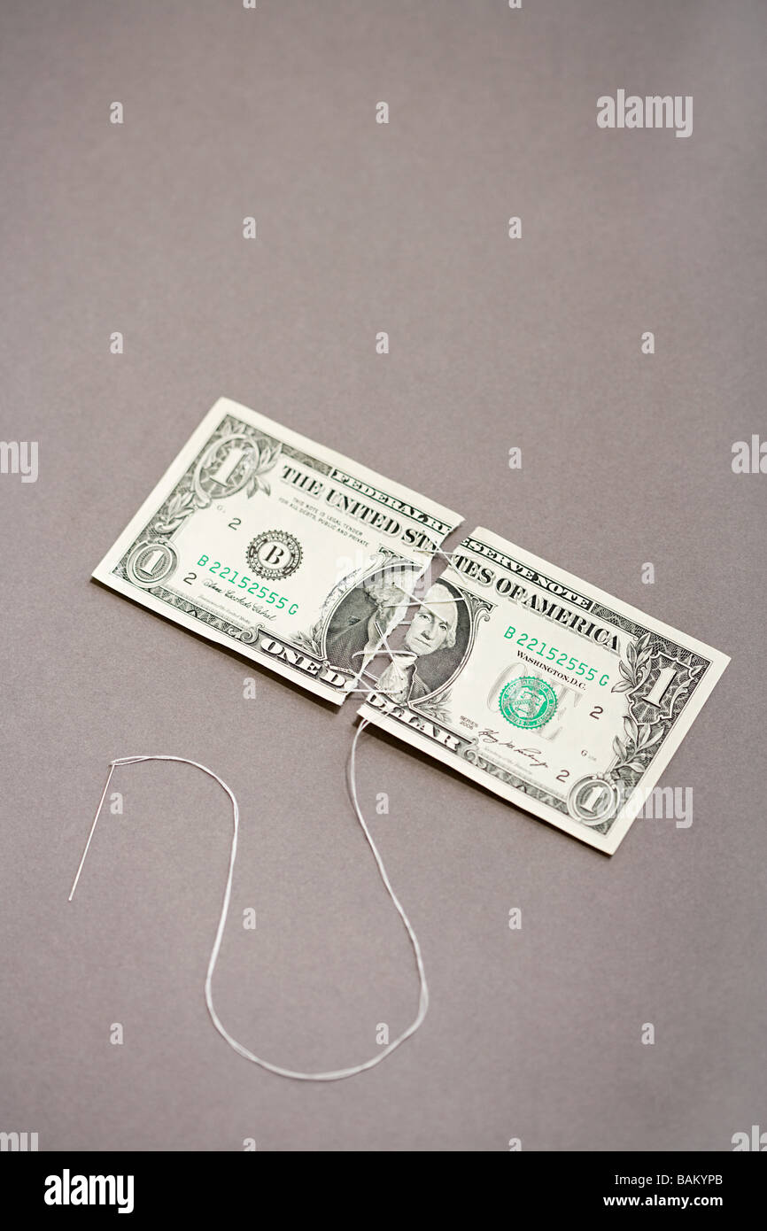Dollar bill being sewn Stock Photo