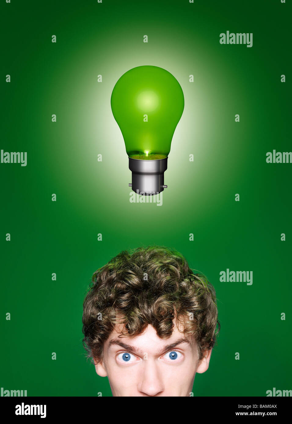 A young man with a green lightbulb over his head Stock Photo