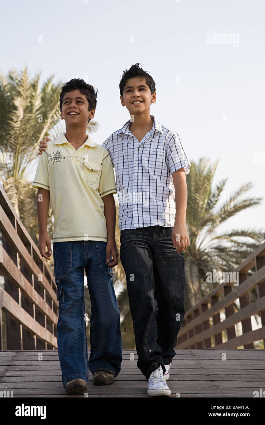 Two boys walking along a bridge Stock Photo