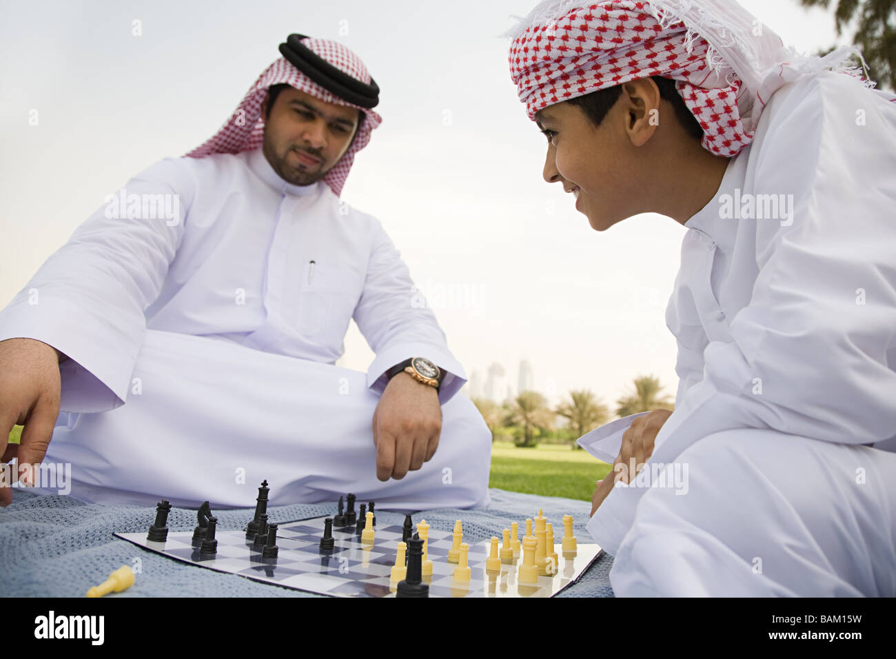 A father and son playing chess in a park Stock Photo
