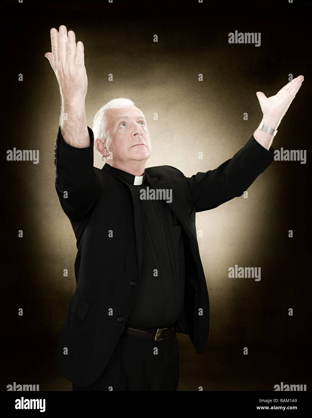 Priest with his arms raised Stock Photo