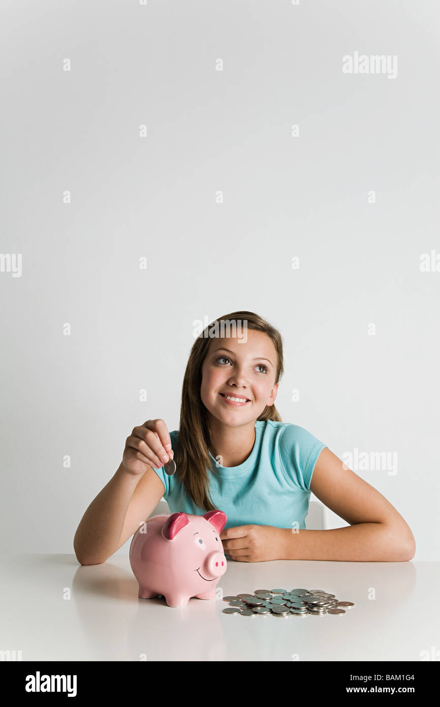 Girl with piggy bank and coins Stock Photo - Alamy